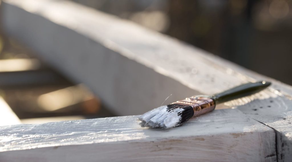 Czym pomalować płot betonowy - pędzel na drewnie